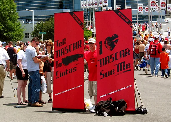 UNITE Cintas protester holding campaign poster as NASCAR event